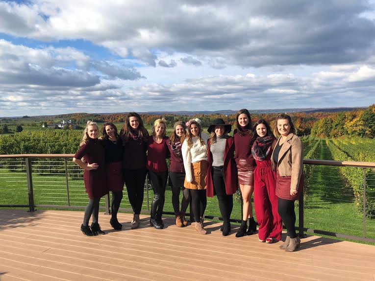 Group of women with a vineyard in the back